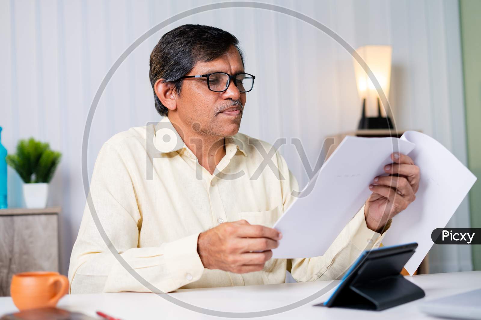 Businessman Checking Or Reading Tax Or Contract Papers At While Working At Office.