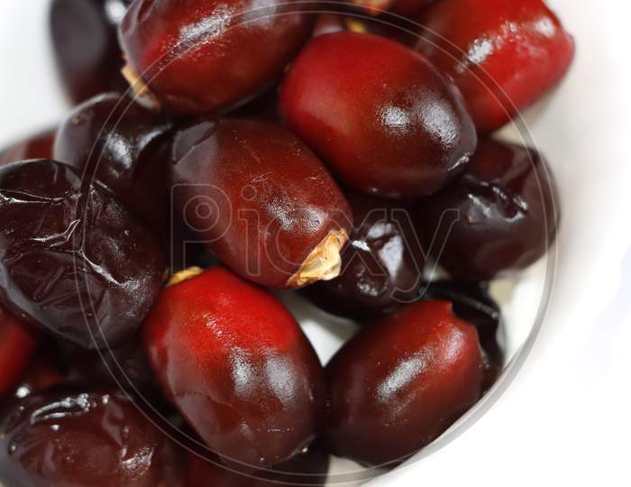 Arabic Dark Red Date Palm Fruits In White Background. Selective Focus
