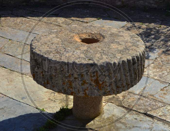 Round stone antique table adorning a courtyard of an ancient building