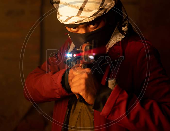 Terrorist Or Gangster With Face Cover Pointing Gun To Camera In Abandoned Place.