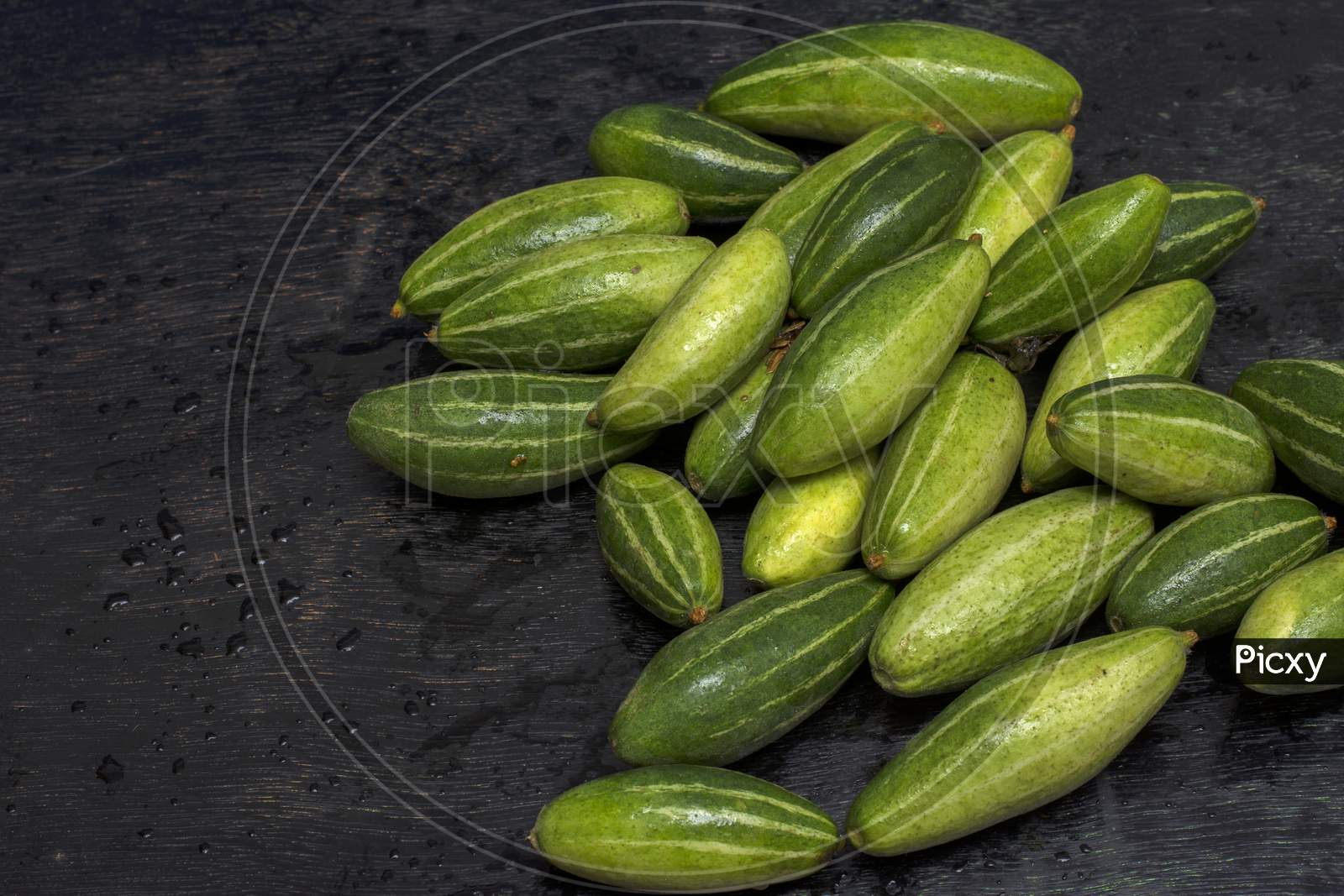 Few Fresh Organic Pointed Gourd On A Black Background With Selective Focus