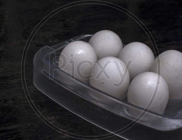 A Trey Full Of Eggs On A Black Background With Selective Focus