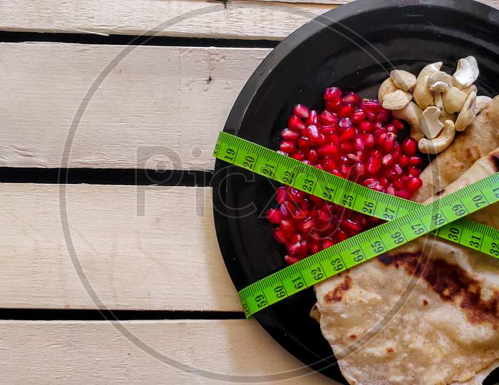Ketogenic Diet concept. Plate of Chapathi, Pomegranate and nuts a composition of balanced diet.