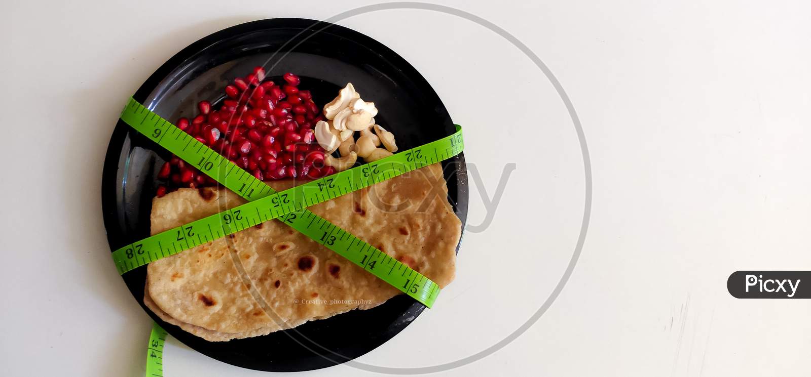 Ketogenic Diet Concept, Plate of Chapathi, pomegranate and nuts a composition of balanced diet.