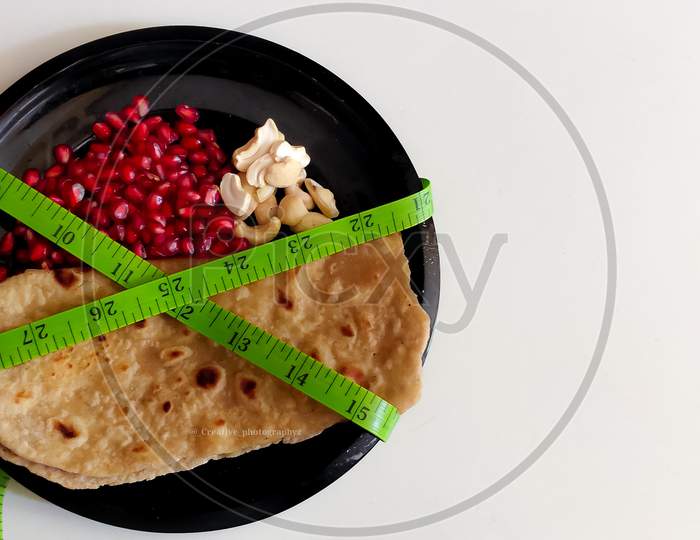 Ketogenic Diet Concept, Plate of Chapathi, pomegranate and nuts a composition of balanced diet.