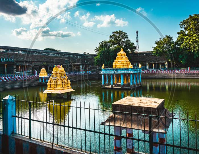 The Great Pond of Varadharaja Perumal Temple and Lord Atthi Varadar Perumal god statue inside the pond, Kanchipuram, Tamil Nadu, South India - Religion and Worship scenario image. Indias Best Tourism