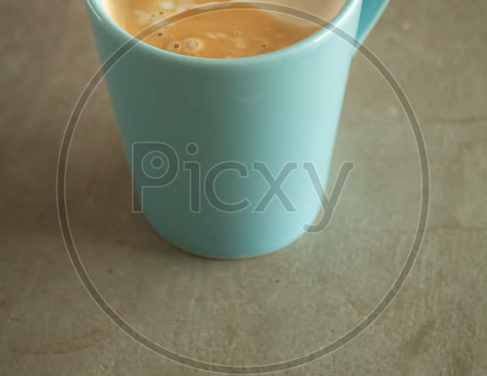 Light Blue Ceramic Mug With Sparkling Coffee On A Gray Concrete Table.
