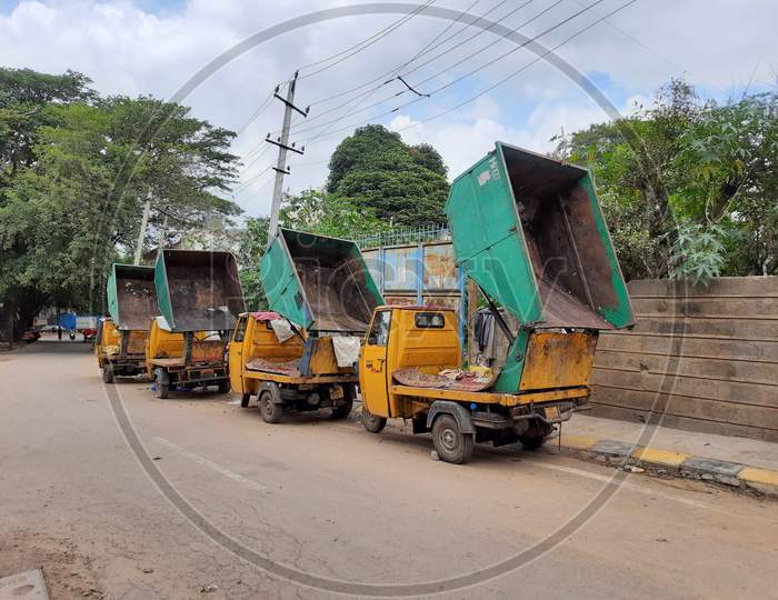 Closeup of BBMP empty auto rickshaw container parking on roadside with opened condition to dry water