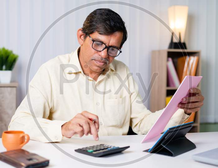 Businessman Checking Or Verifying Bills, Expenses Or Taxes And Calculating Be Seeing Bills And Calculator At Office - Concept Of Managing Budget And Financial Work.