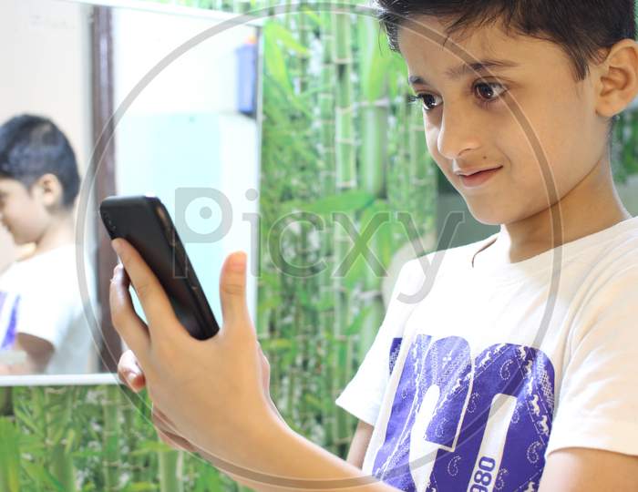 Kid Looking at mobile screen. Cut boy looking at mobile screen.
