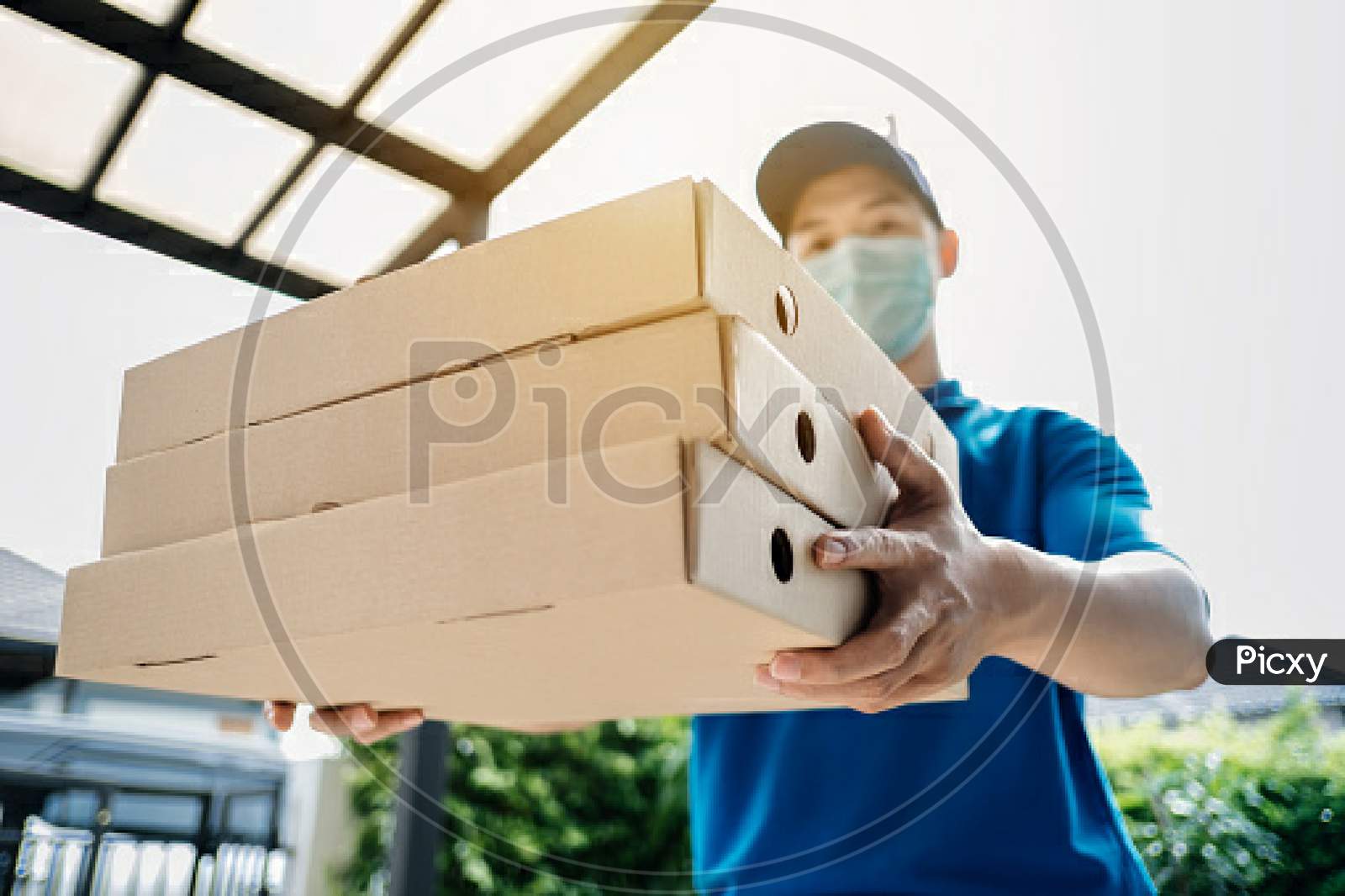 Asian Delivery Man Wearing Mask Send A Pizza Food On Front Home Receiver Shipping Deliver Social Distancing While The Virus Is Spreading And Prevention Crisis Coronavirus Covid-19 Front Home Customer.