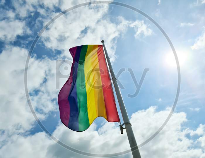 Rainbow Pride Flag Illustration. Lgbt Community Symbol In Rainbow Colors Against The Blue Sky .