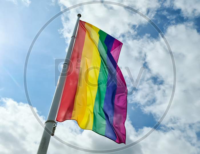 Rainbow Pride Flag Illustration. Lgbt Community Symbol In Rainbow Colors Against The Blue Sky .