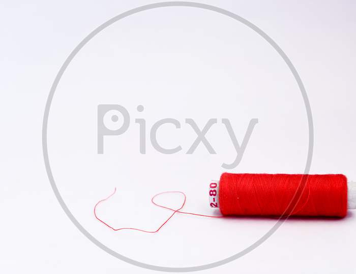 Single Spools Of Thread On White Background With Copy Space.