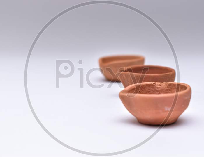 Indian Clay Diyas Or Oil Lamps In Series With White Background