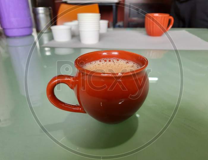 Single Red Or Brown Color Clay, Sand Coffee Cup On A Table