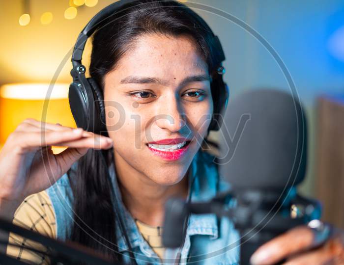 Close Up Head Shot Of Happy Cheerful Young Girl Podcasting By Looking Camera - Concept Of Woman Blogger Or Dj Working On Broadcasting Studio.