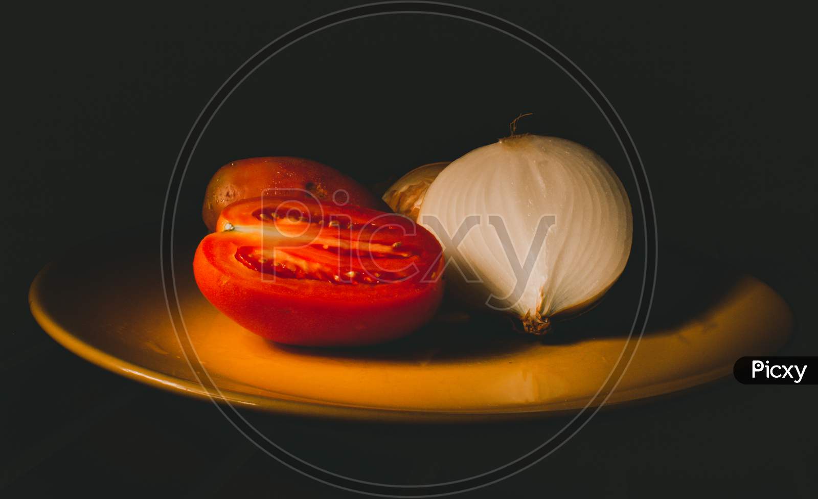 Tomatoes And Onions On A Yellow Plate. Still Life Effect Created With Light.