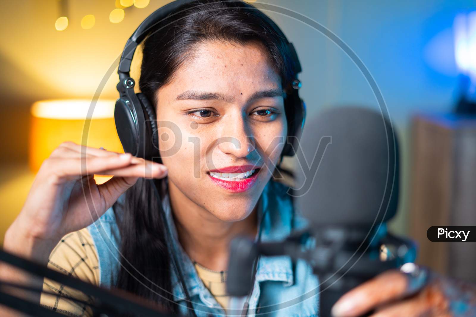Close Up Head Shot Of Happy Cheerful Young Girl Podcasting By Looking Camera - Concept Of Woman Blogger Or Dj Working On Broadcasting Studio.