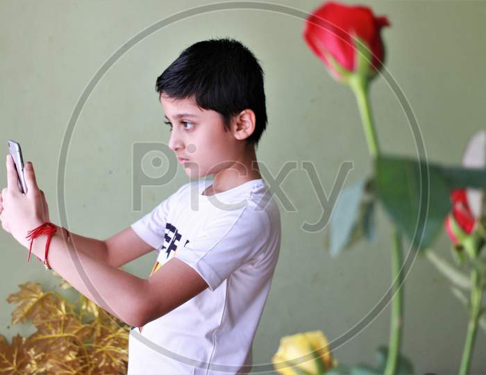 Kid Looking At Mobile Screen. Cute Boy Looking At Mobile Screen. Playing on mobile