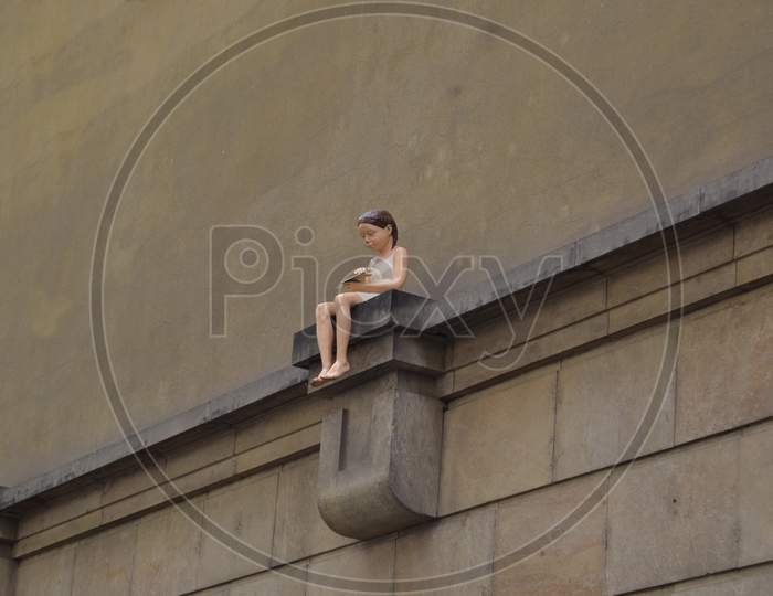 Girl With A Paper Plane On A Wall