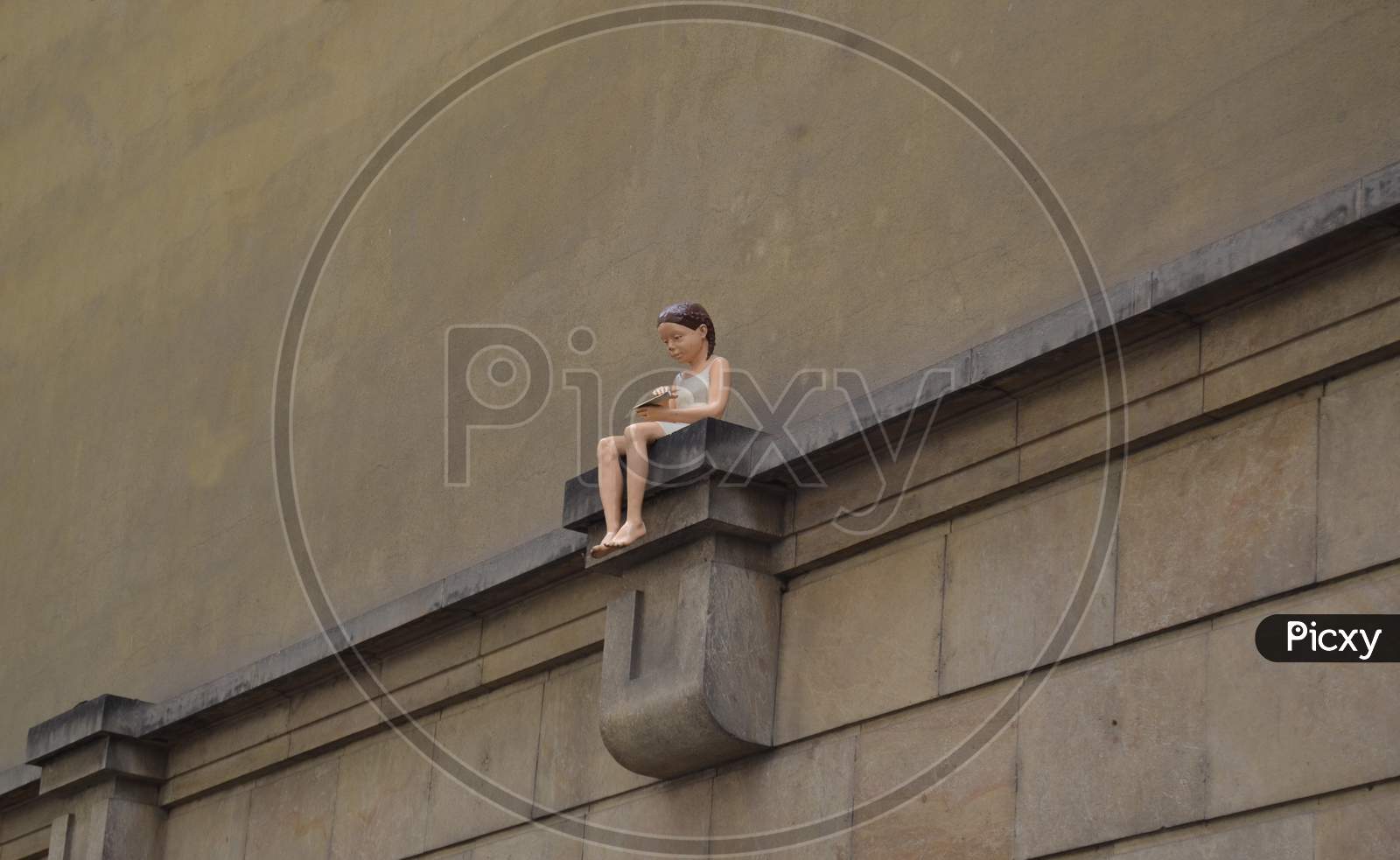 Girl With A Paper Plane On A Wall