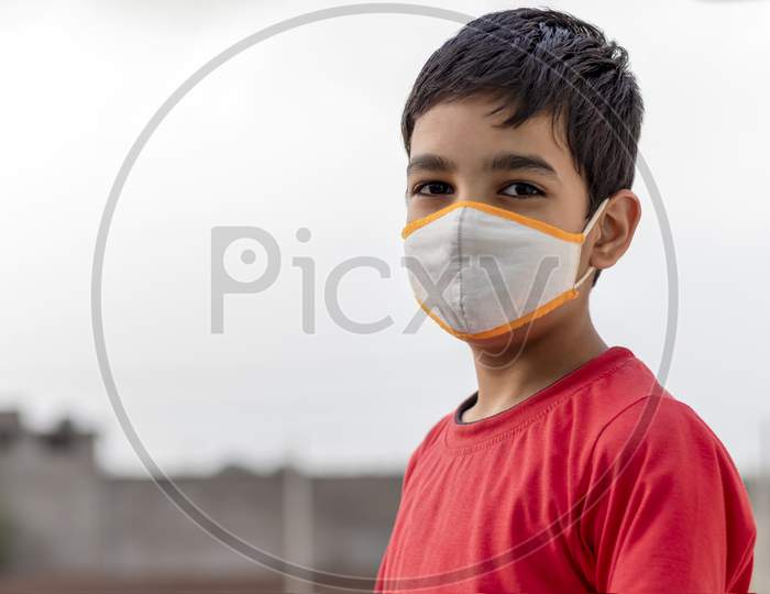 Little Indian cute boy wearing mask during corona virus and flu outbreak. Mask for corona virus prevention.