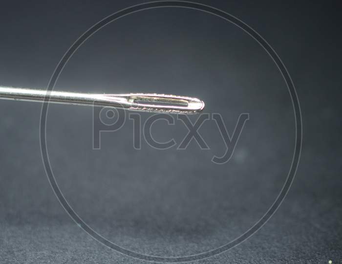 Small Needle With Empty Eyelet, Isolated Over The Black Background.