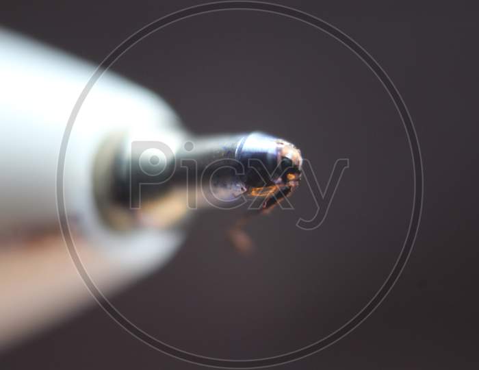 Macro Photo Of Ballpoint Pen Tip With Dark Grey Background.