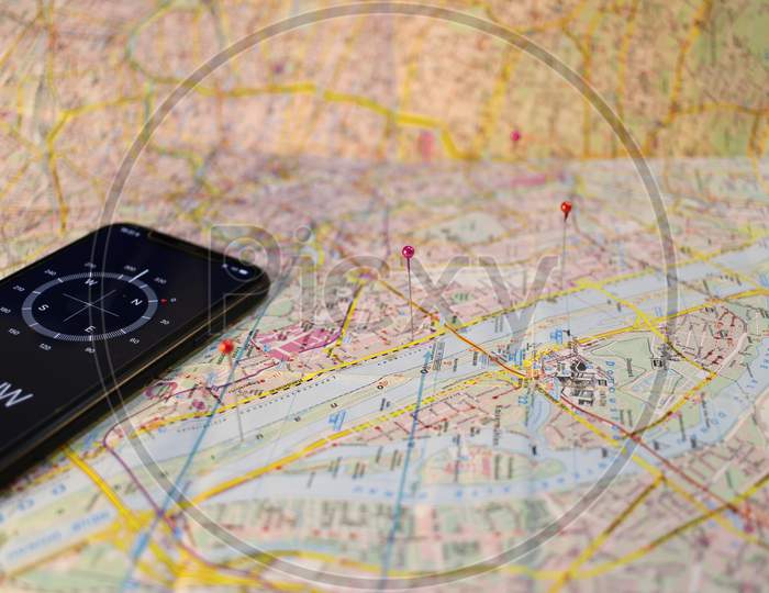 ocation marking with a pin on routes on map. Adventure, discovery, navigation, communication, logistics, geography, transport and travel theme concept background. Mobile compass and Map.
