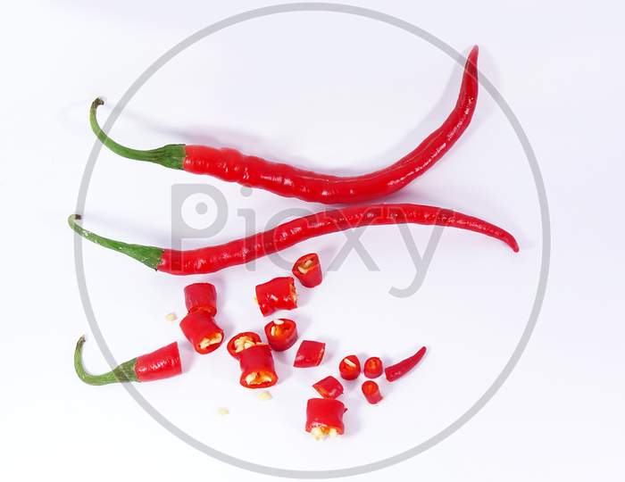 Group of red cut chili peppers isolated on white background .