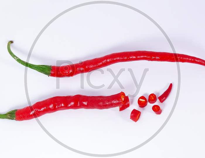 Group of red cut chili peppers isolated on white background .