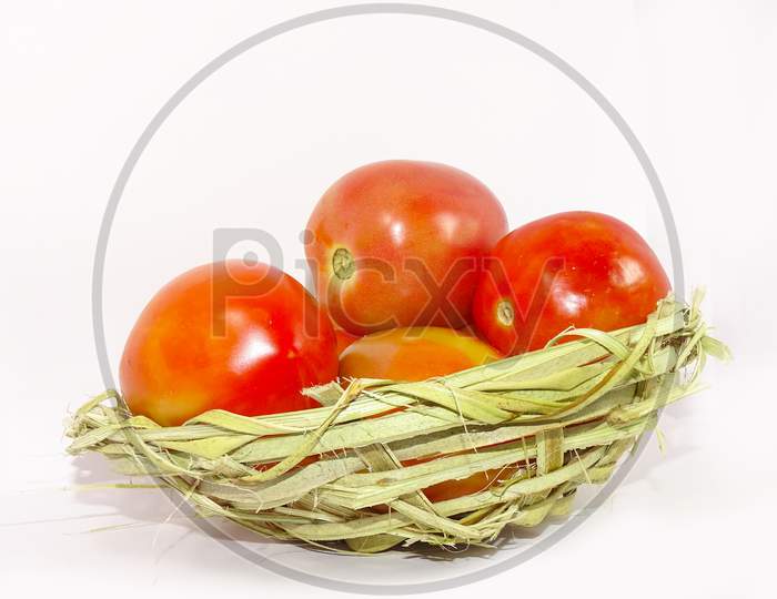 Fresh red tomatoes in basket isolated on white background.