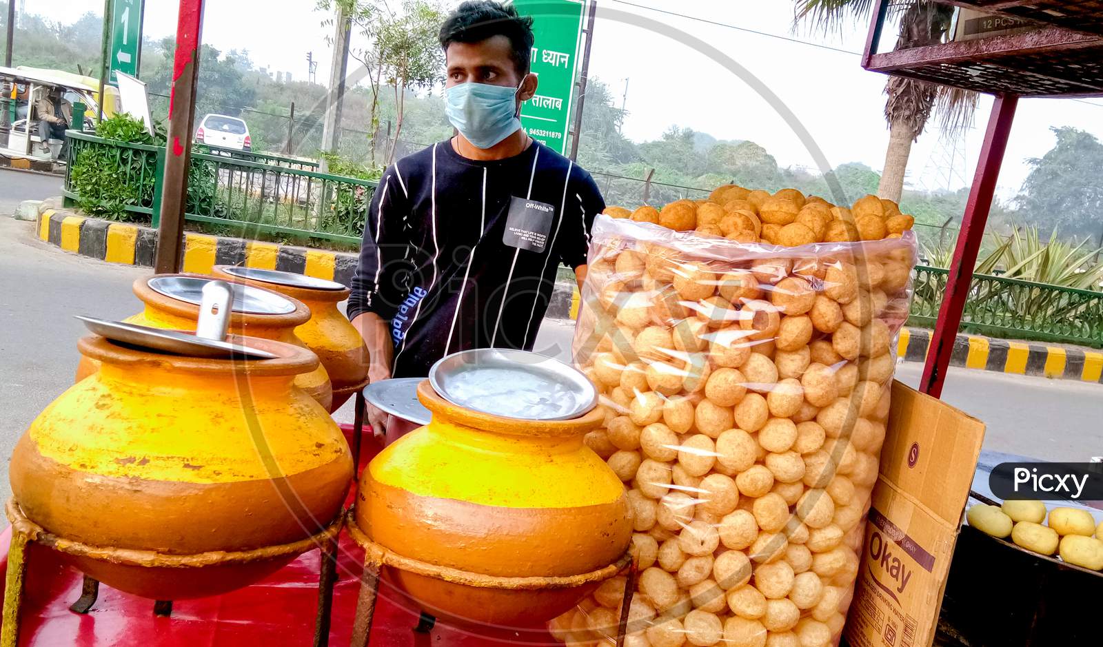 A Man Wearing A Mask Selling Golgappas On The Street