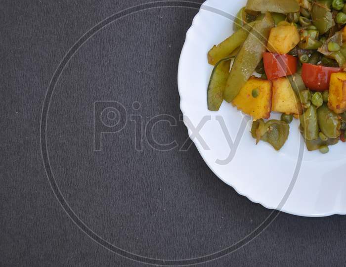 Top view of matar paneer mix veg recipe (Indian food) over black color background with copy space for text