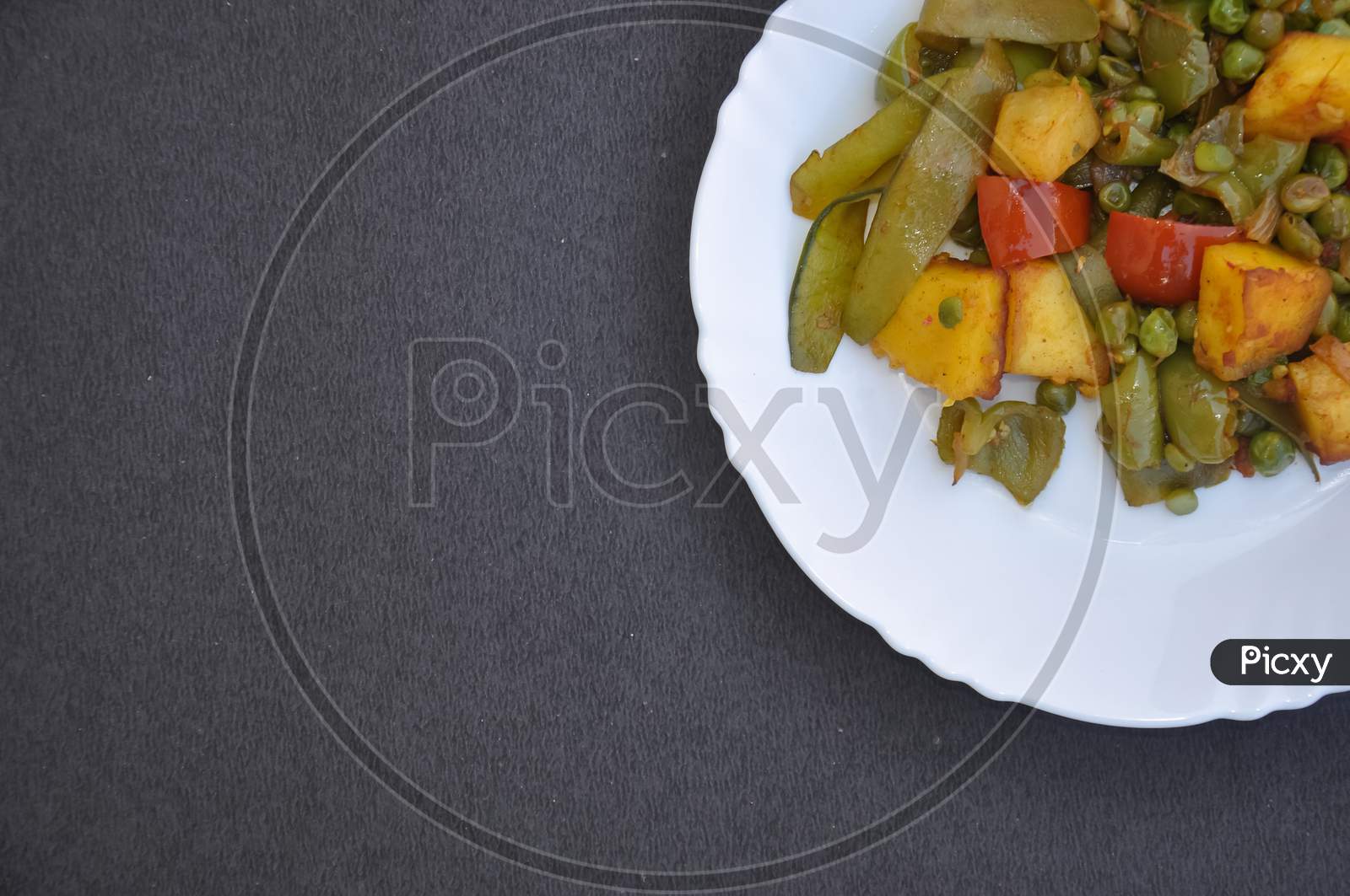 Top view of matar paneer mix veg recipe (Indian food) over black color background with copy space for text
