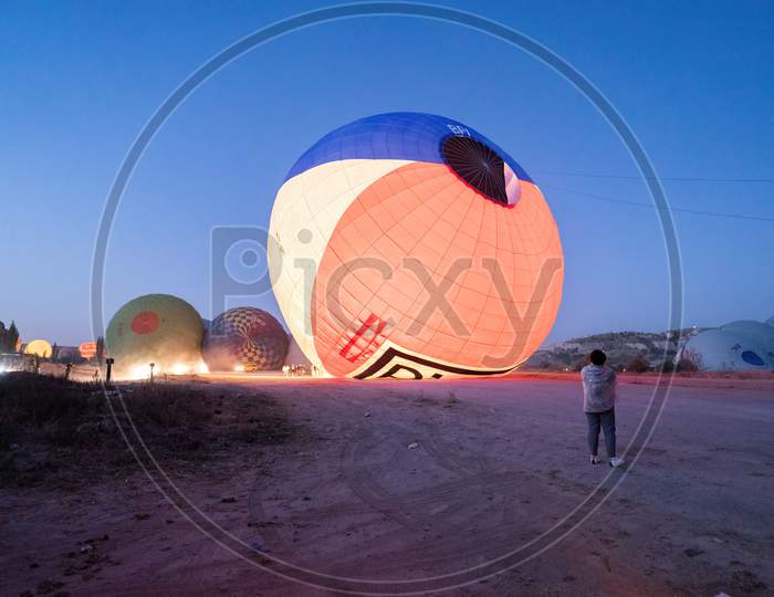 Cappadocia, Turkey - September 14, 2021: Air Hot Air Balloons Being Filled With Helium Gas During Night, Preparation Of A Flight In Goreme National Park In Cappadocia, Turkey