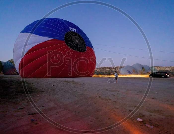 Cappadocia, Turkey - September 14, 2021: Air Hot Air Balloons Being Filled With Helium Gas During Night, Preparation Of A Flight In Goreme National Park