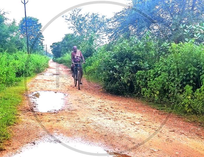 Village old man cycle on road