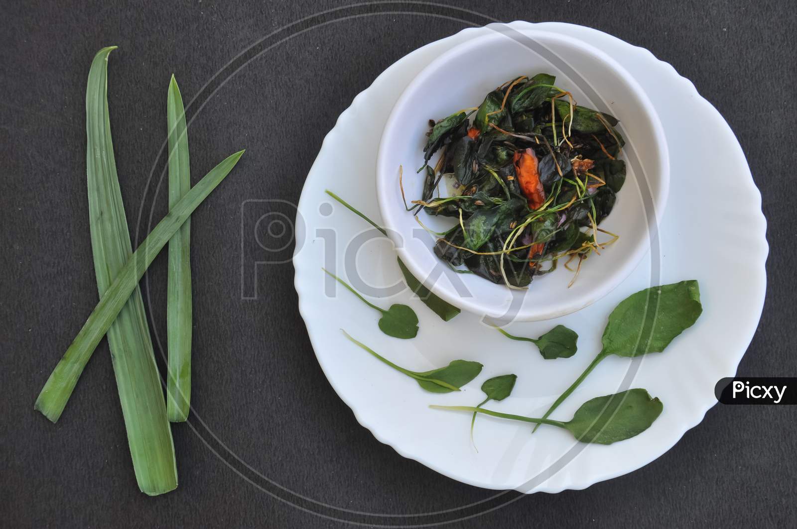 Overhead view of saag (greens) recipe over black background