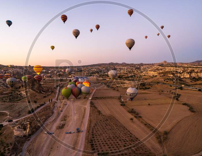 Cappadocia, Turkey - September 14, 2021: Wide Angle Aerial Shot Of Colorful Hot Air Balloons Together Floating In The Sky At Early Morning In Goreme