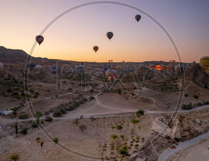Cappadocia, Turkey - September 14, 2021: Vertical Shot Of Hot Air Balloons Flying About Goreme National Park During Early Morning