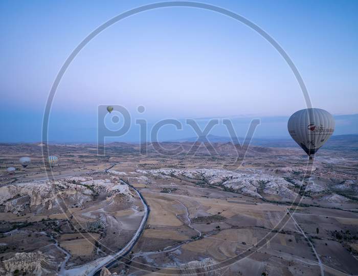 Cappadocia, Turkey - September 14, 2021: Wide Angle Aerial Shot Of Colorful Hot Air Balloons Together Floating In The Sky At Early Morning Sunrise Horizon In Goreme National Park