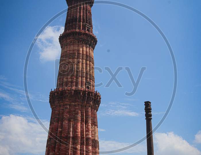 Iron pillar in comparison of Qutub Minar