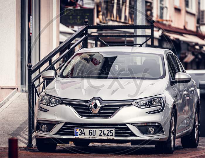 Alanya, Turkey – April 17 2021:   Silver  Renault Megane Is Parked  On The Street In City Against The Backdrop Of A Buildung,  Shops