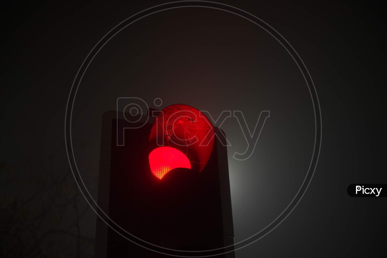 A British Traffic Light Shines Red, Indicating Stop, During Night Fog