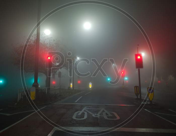Colored Traffic Lights And White Street Lamps Shine Through Thick Fog
