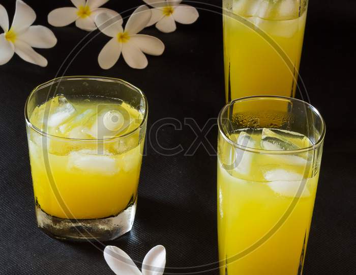 Fresh orange juice glasses isolated on black background.