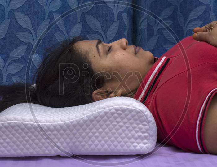 A Young Lady Sleeping On A Orthopedic Memory Foam Pillow With Comfort.