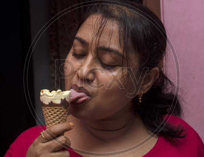 A Young Lady Enjoying Cone Ice Cream. Selective Focus.